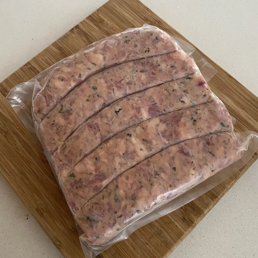 Chorizos antioqueños crudos empacados al vacío sobre tabla de madera